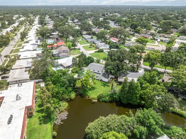 an aerial view of residential houses with outdoor space and trees