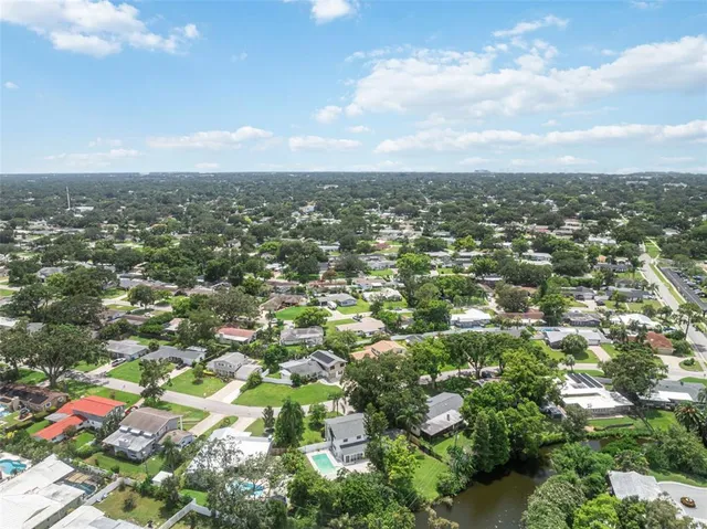 an aerial view of residential houses with outdoor space and trees