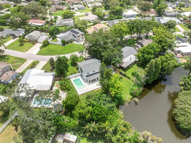 an aerial view of a house with a yard and lake view