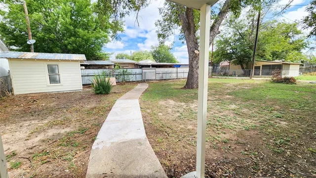 a view of a backyard with large tree