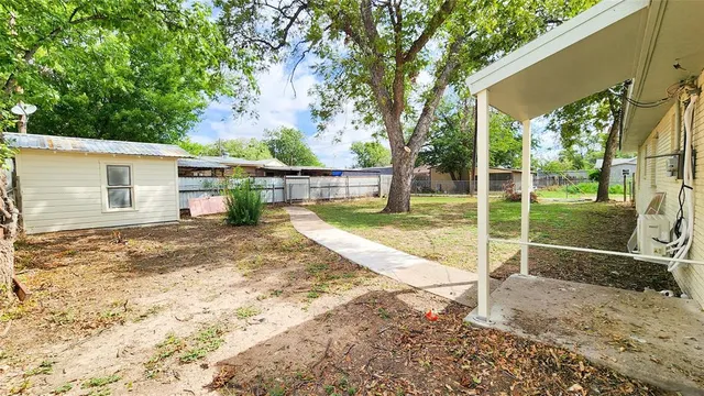 a view of a house with backyard and a tree