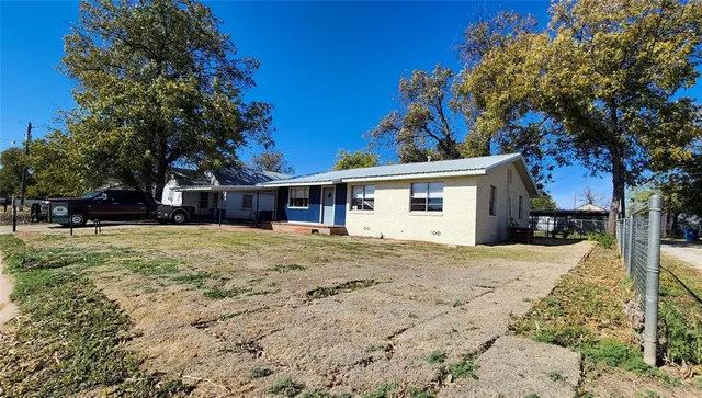 a view of a house with a tree in the yard