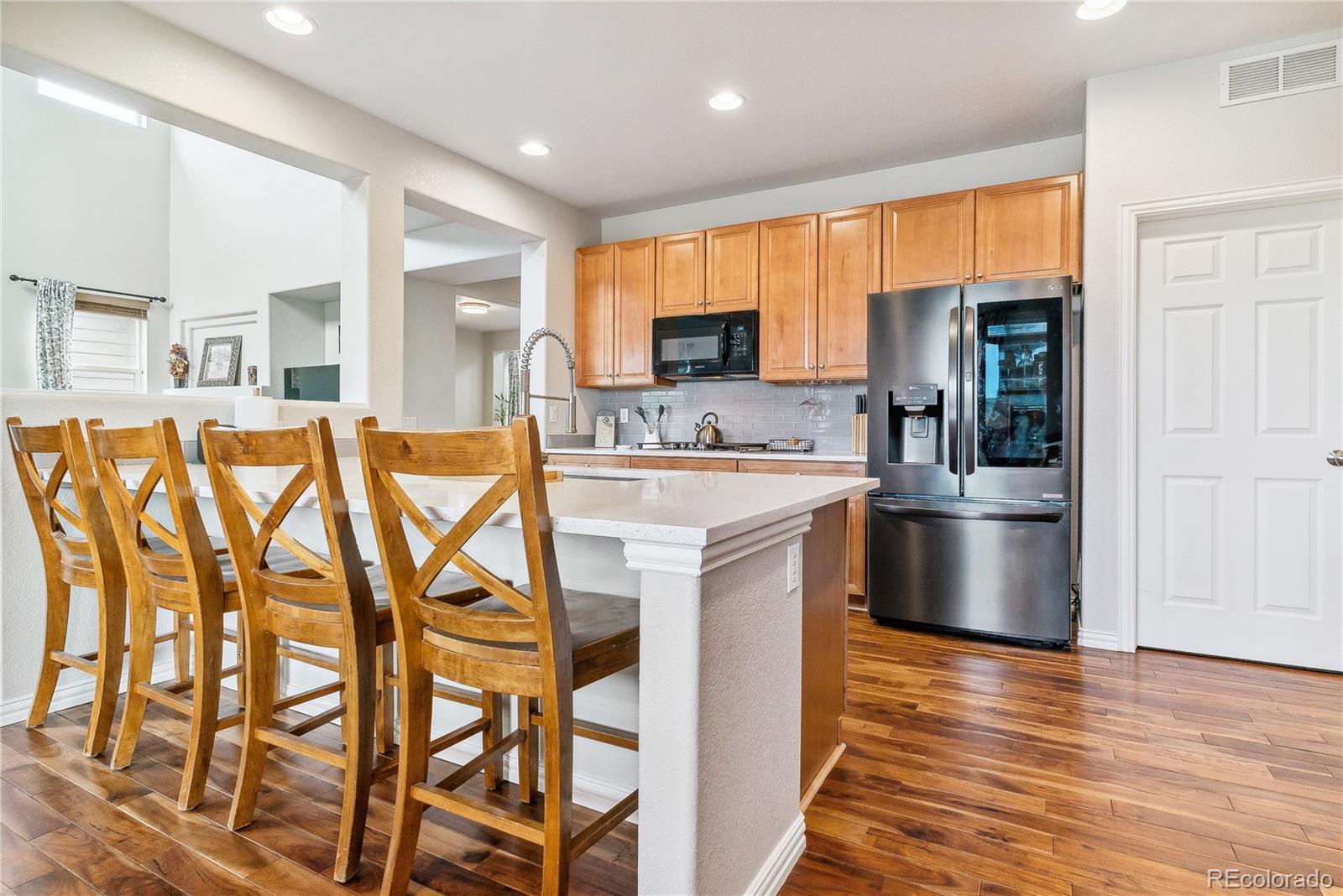 3477 Softwind Point Castle Rock, CO 80108 - Photo 17 of 50 a kitchen with stainless steel appliances granite countertop a stove a sink and a refrigerator