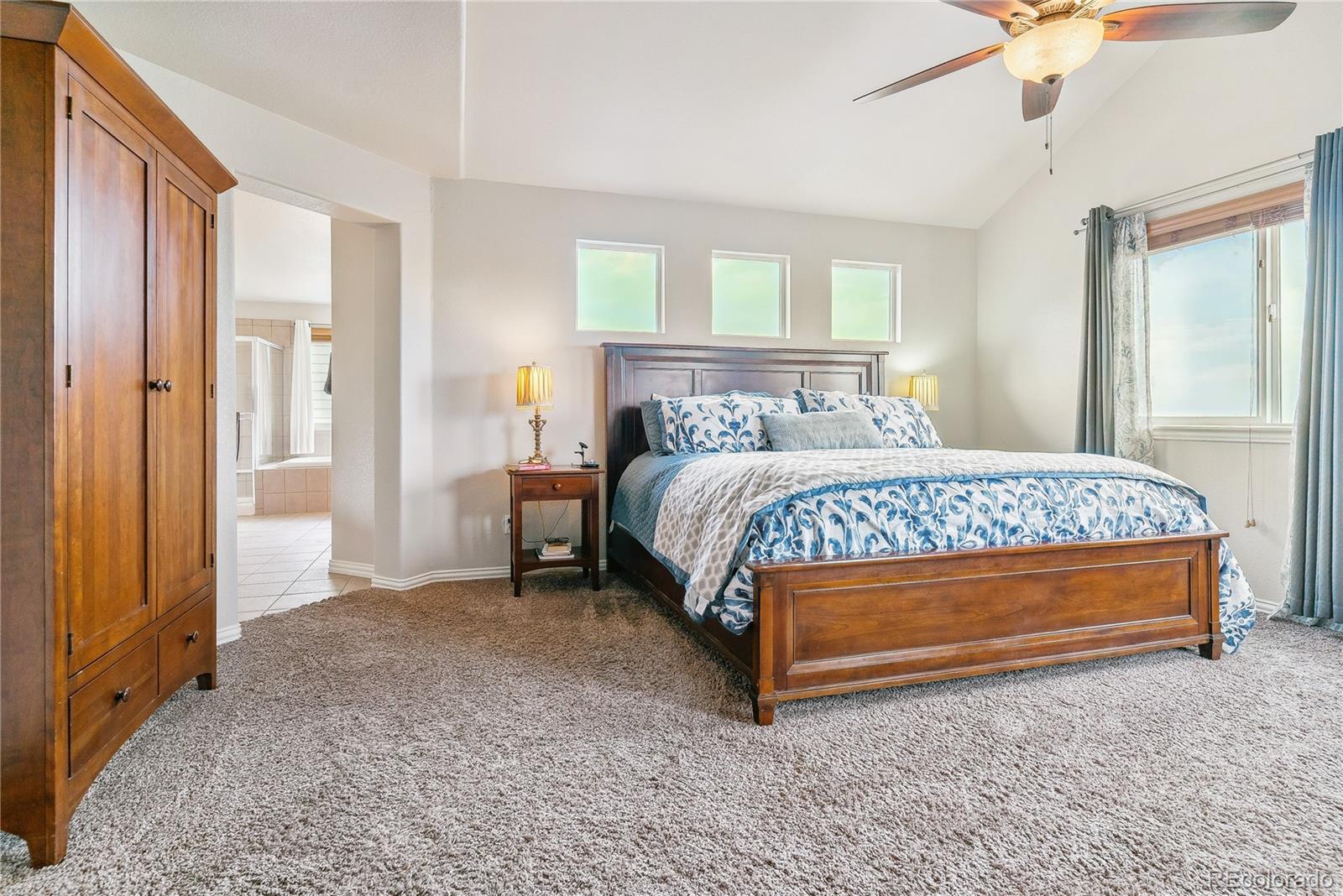 3477 Softwind Point Castle Rock, CO 80108 - Photo 18 of 50 a bedroom with a bed and large windows