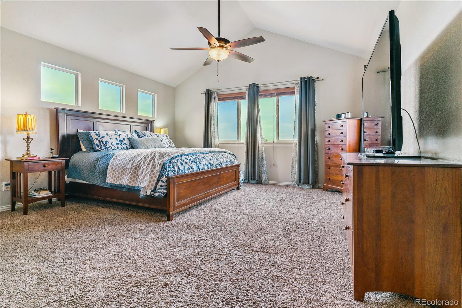 3477 Softwind Point Castle Rock, CO 80108 - Photo 20 of 50 a spacious bedroom with a bed dresser and a window