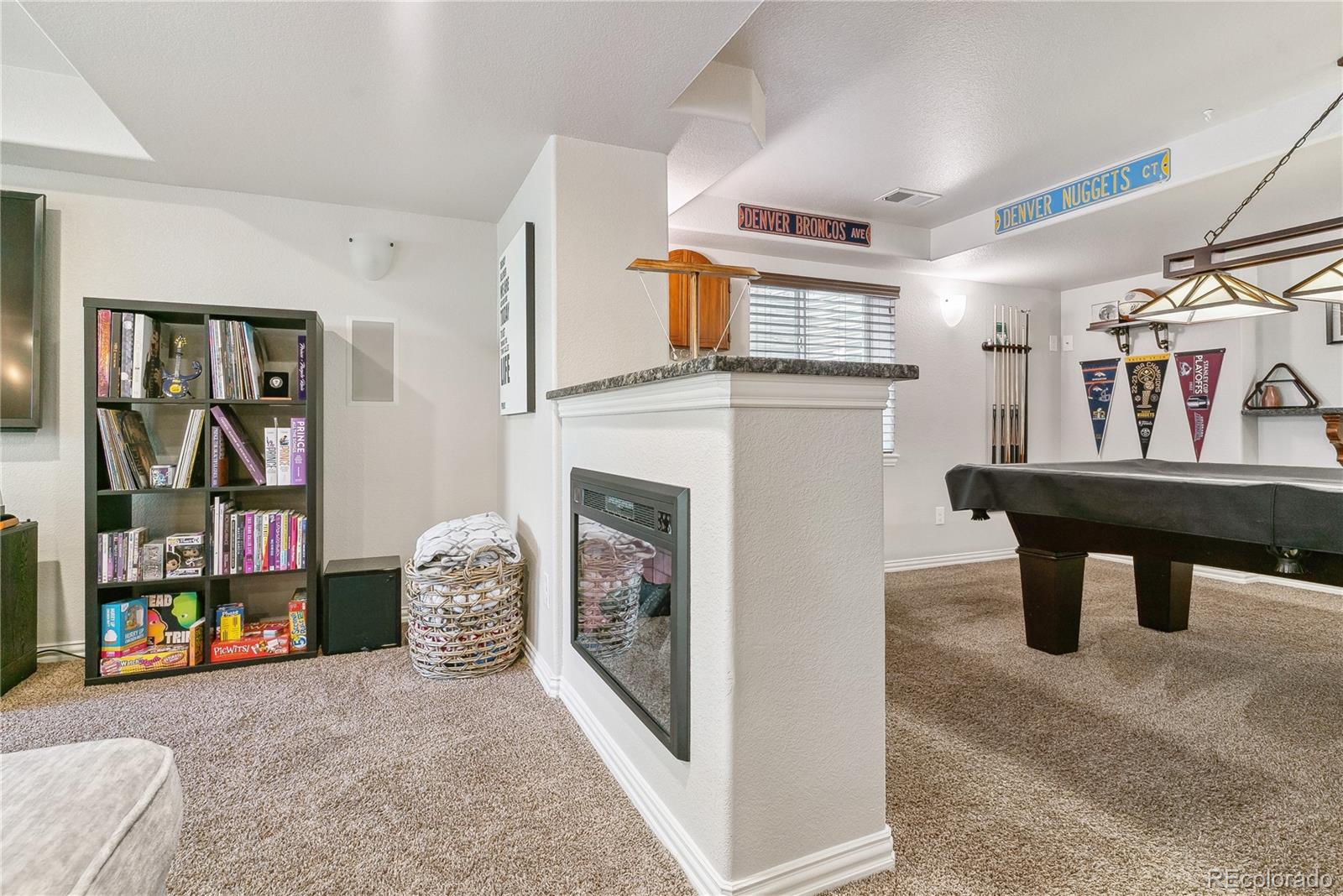 3477 Softwind Point Castle Rock, CO 80108 - Photo 35 of 50 a living room with furniture and a fireplace