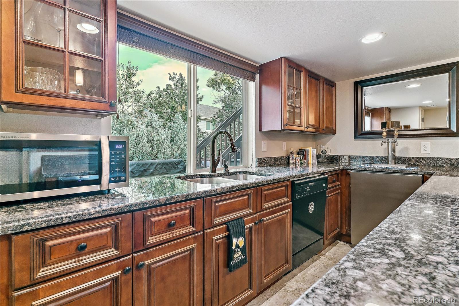 3477 Softwind Point Castle Rock, CO 80108 - Photo 37 of 50 a kitchen with granite countertop a sink and a stove