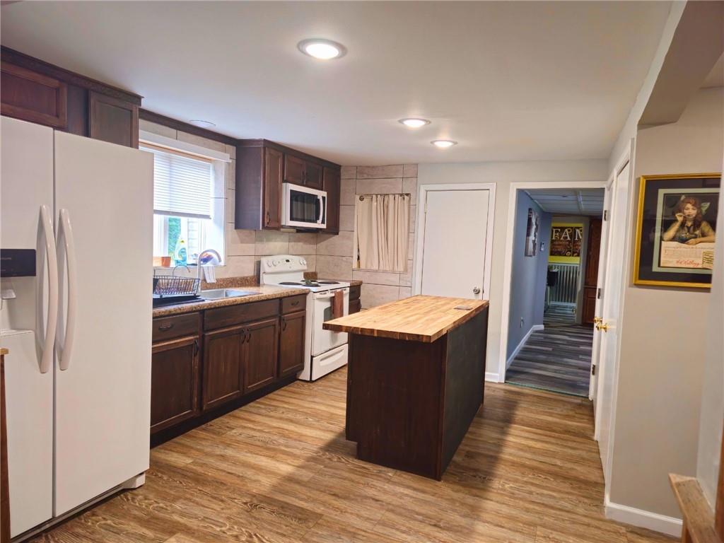 1088 Burns Road Kennerdell, PA 16374 - Photo 14 of 49 a kitchen with stainless steel appliances granite countertop a refrigerator a sink dishwasher a oven with wooden cabinets and floors