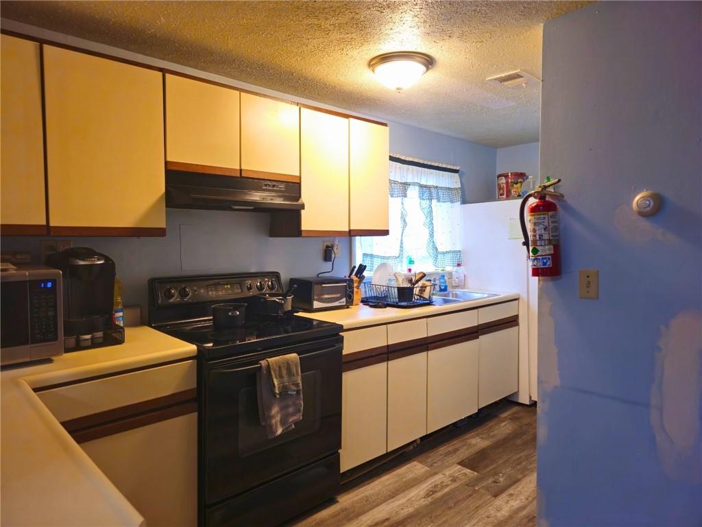 1088 Burns Road Kennerdell, PA 16374 - Photo 42 of 49 a kitchen with stainless steel appliances a stove a sink and a refrigerator