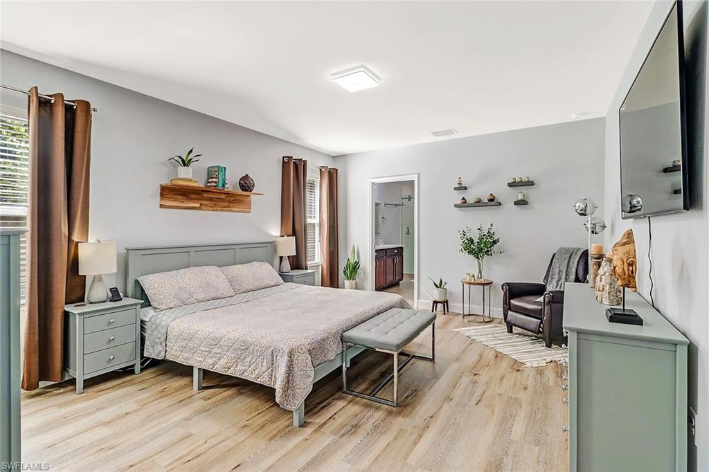 690 Hadley Place East Naples, FL 34104 - Photo 14 of 27 a bedroom with a bed and wooden floor