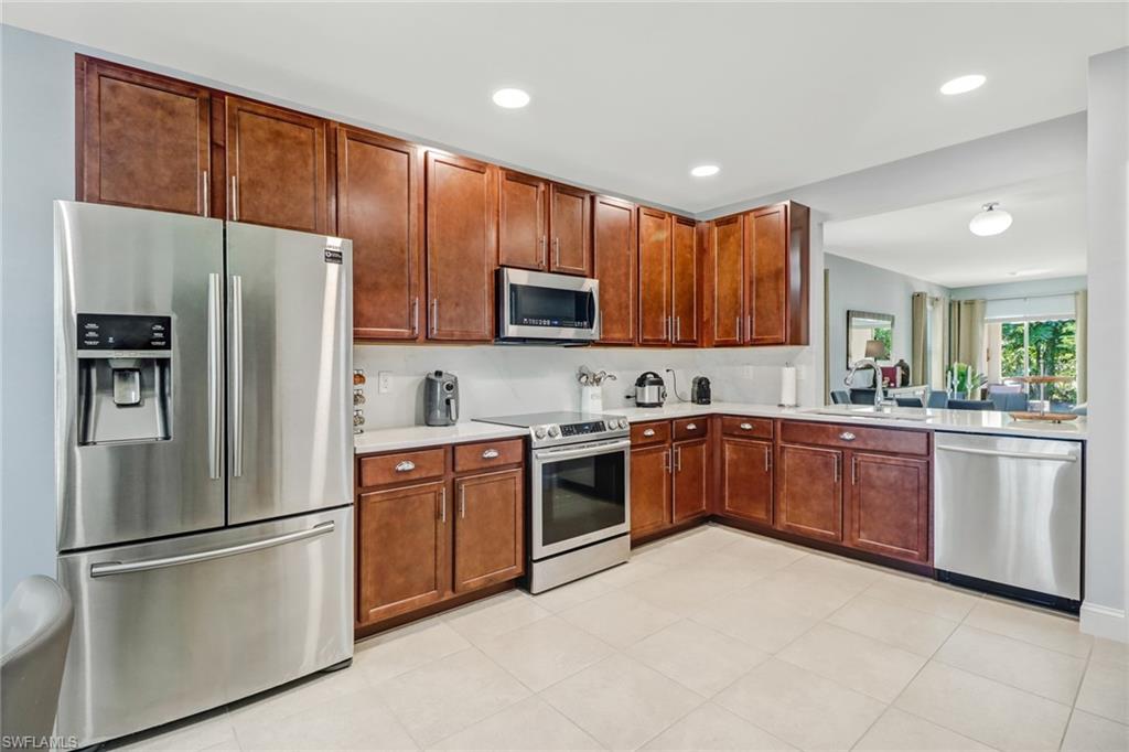 690 Hadley Place East Naples, FL 34104 - Photo 3 of 27 a kitchen with granite countertop stainless steel appliances and refrigerator