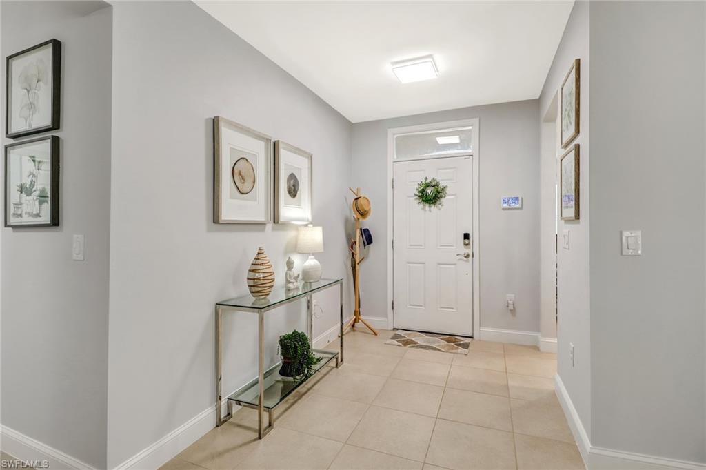 690 Hadley Place East Naples, FL 34104 - Photo 4 of 27 a view of a hallway with paintings on the wall
