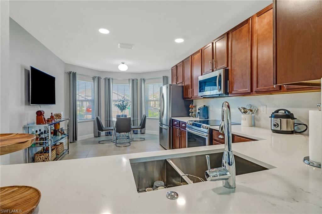 690 Hadley Place East Naples, FL 34104 - Photo 8 of 27 a kitchen with stainless steel appliances granite countertop a refrigerator and a sink