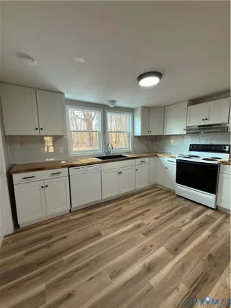 a kitchen with granite countertop a sink stainless steel appliances and cabinets
