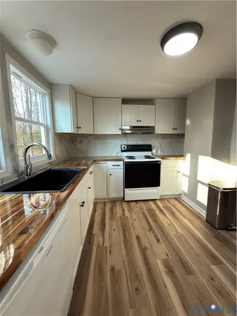 a large kitchen with stainless steel appliances granite countertop a stove a sink and a granite counter tops