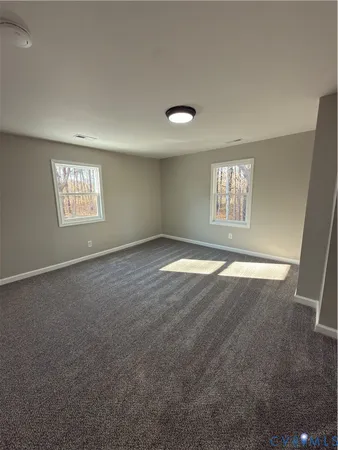 an empty room with windows and closet