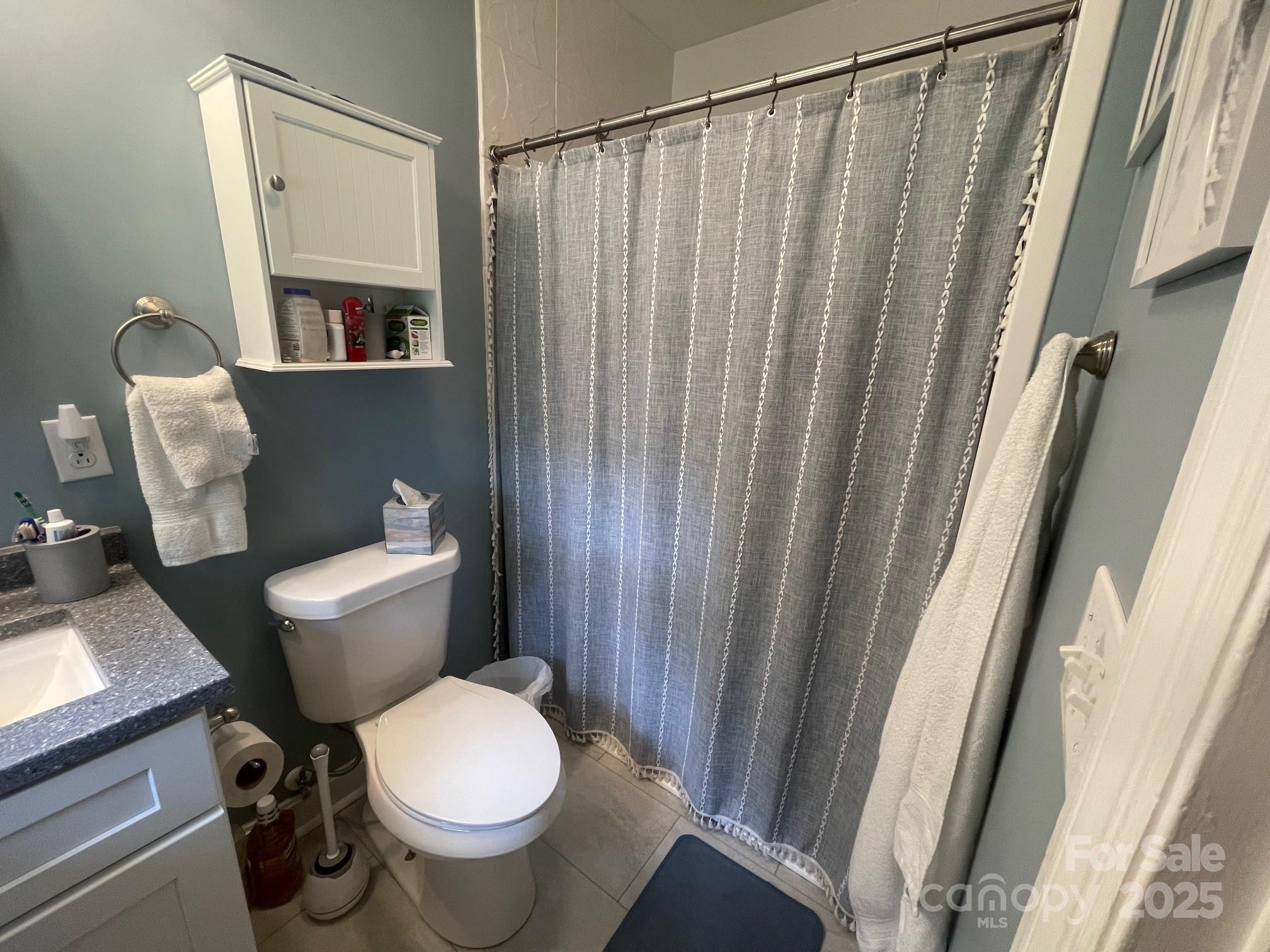 107 Calhoun Drive Cheraw, SC 29520 - Photo 14 of 16 a white toilet sitting next to a shower curtain