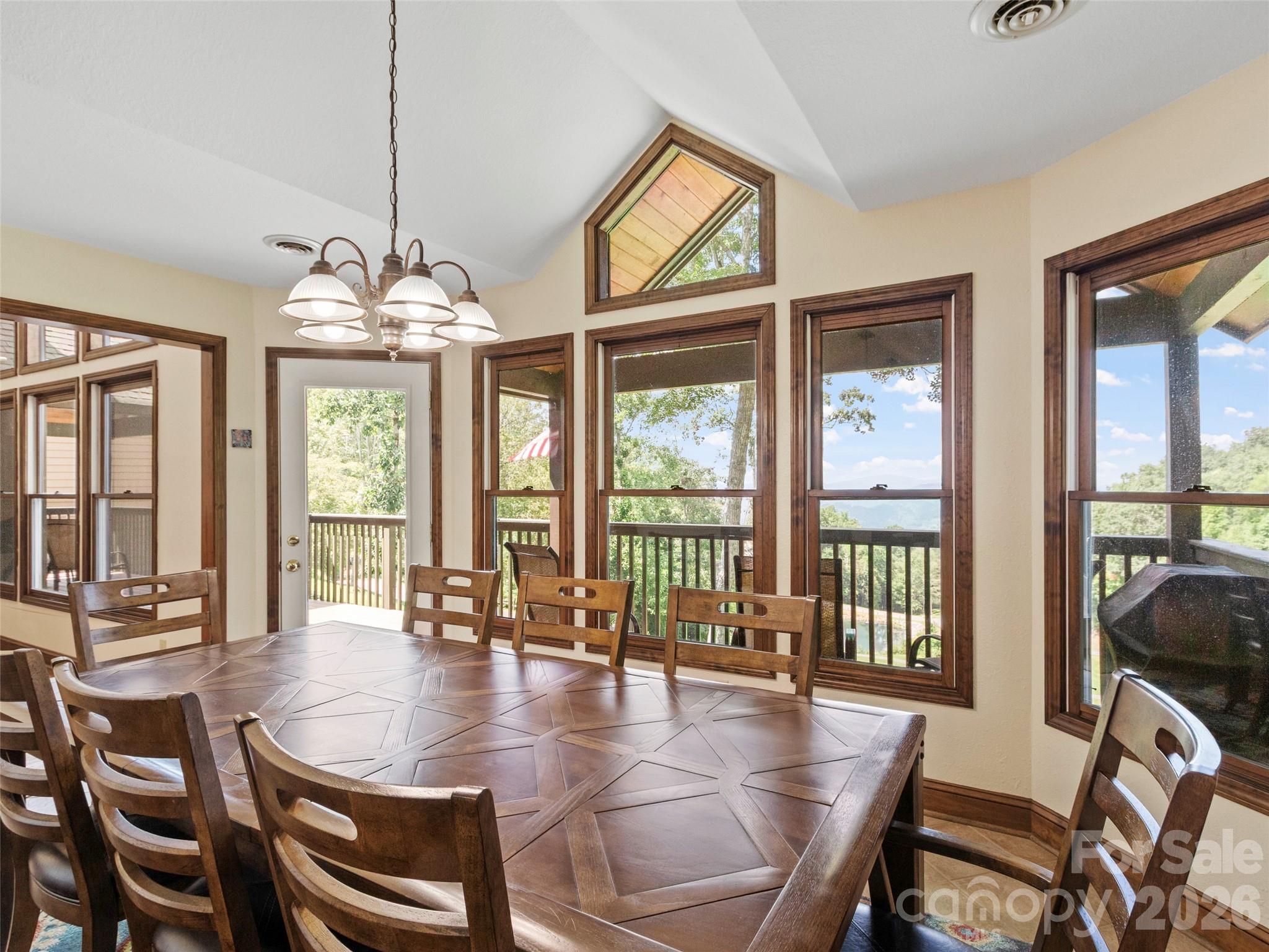 91 Brandy Run Road Burnsville, NC 28714 - Photo 11 of 45 a dining room with wooden floor a chandelier a glass table and chairs