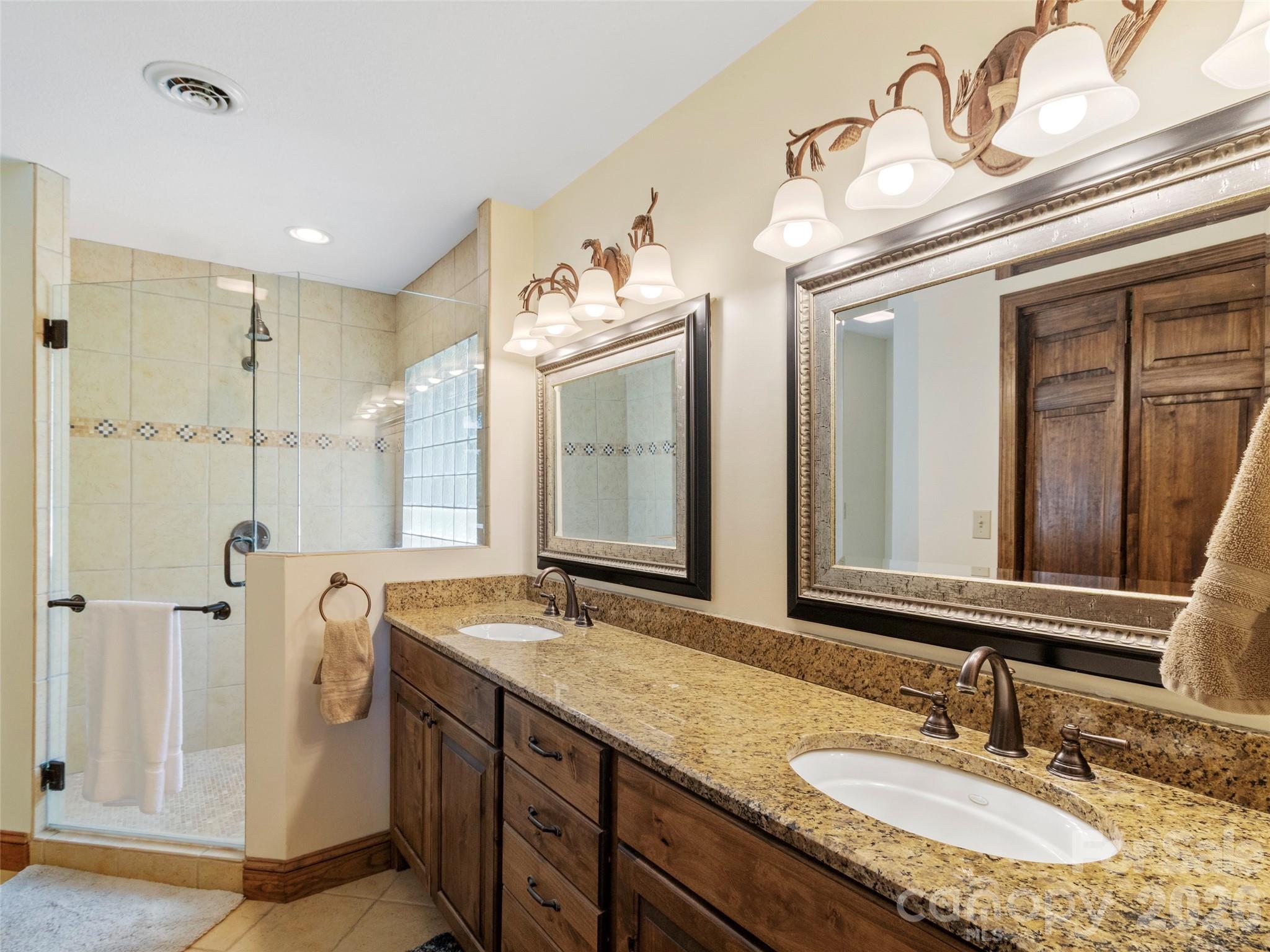 91 Brandy Run Road Burnsville, NC 28714 - Photo 19 of 45 a bathroom with a granite countertop double vanity sink and mirror