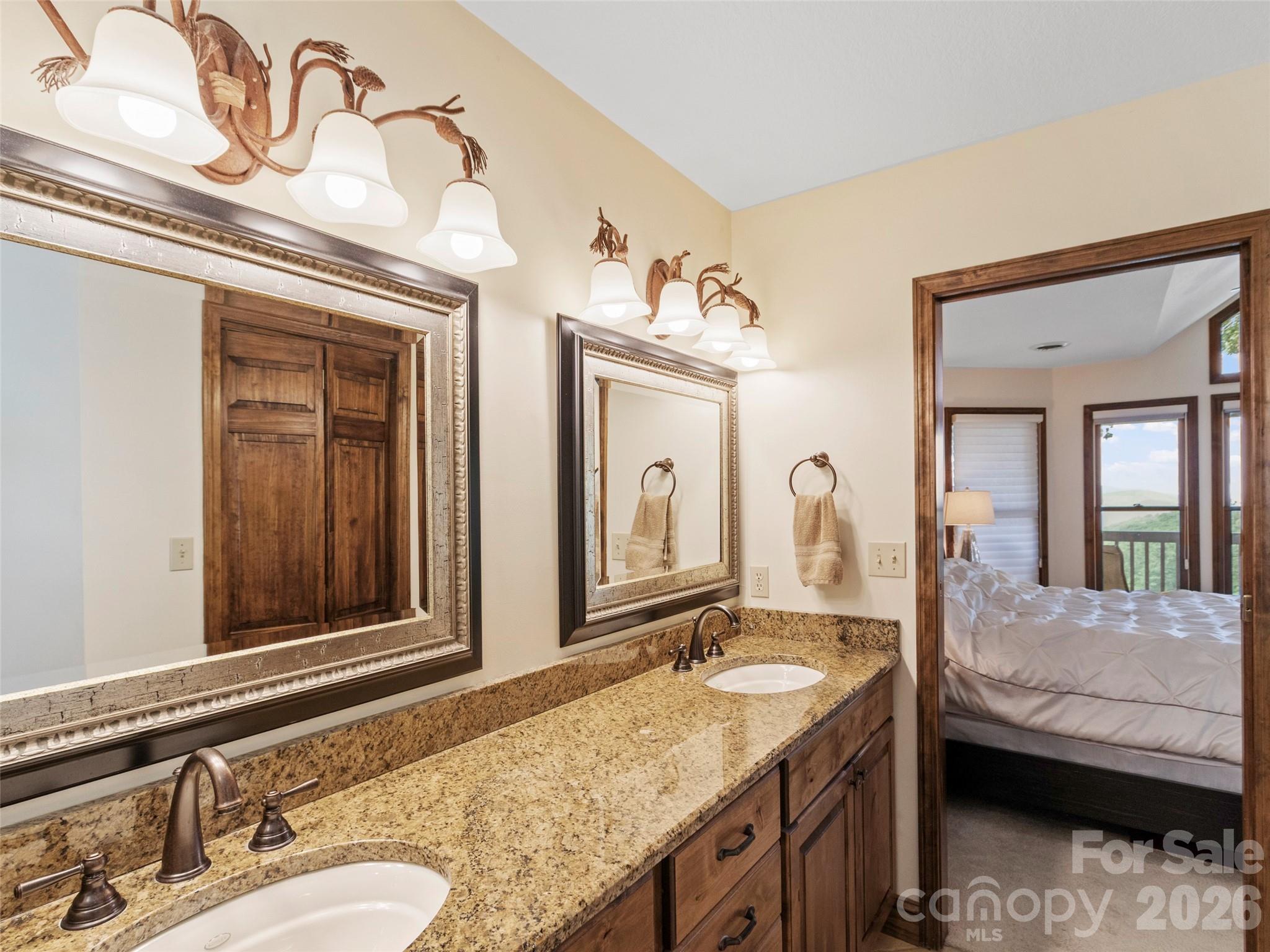 91 Brandy Run Road Burnsville, NC 28714 - Photo 22 of 45 a en suite bathroom with a granite countertop sink and a mirror