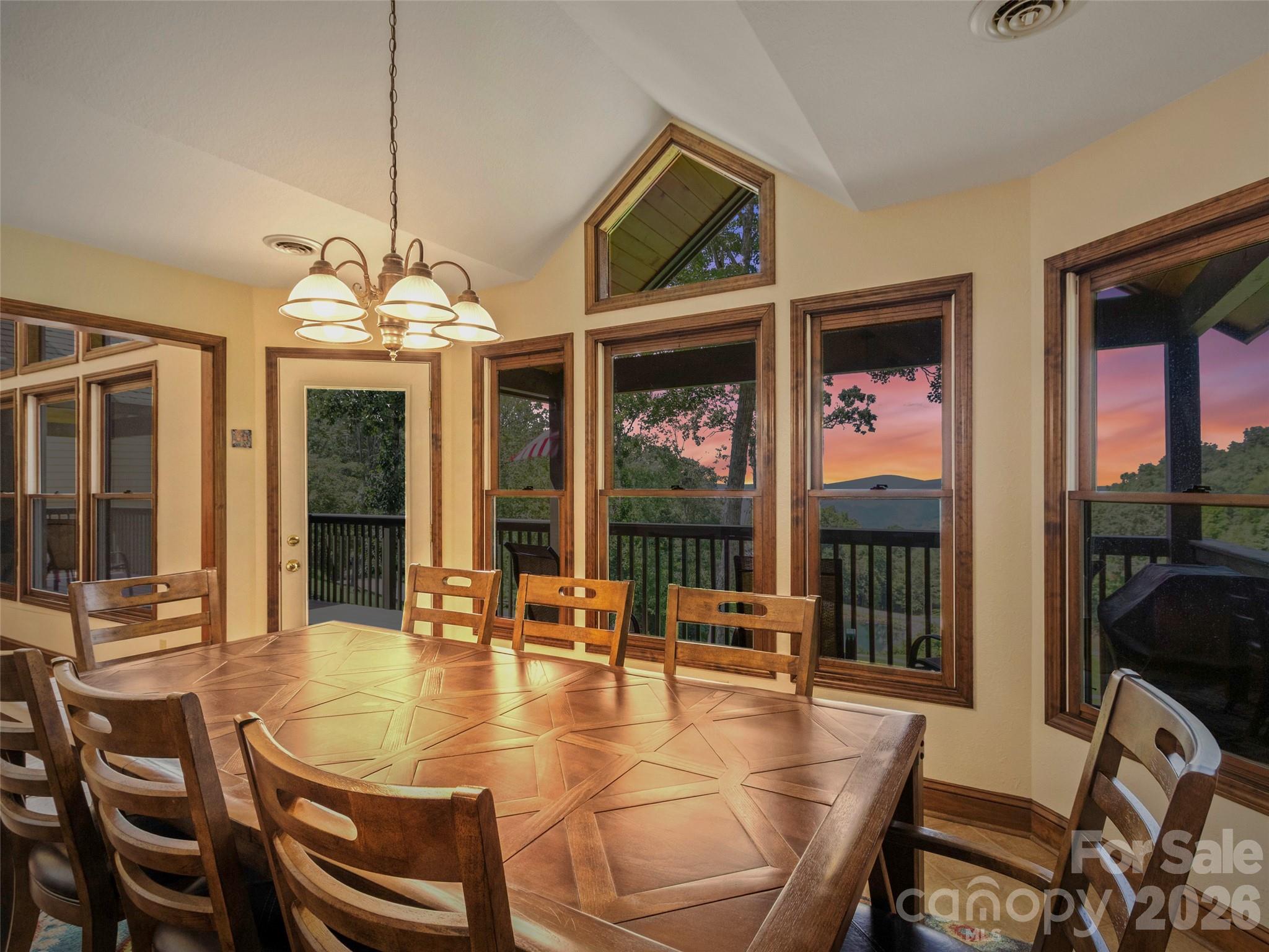 91 Brandy Run Road Burnsville, NC 28714 - Photo 45 of 45 a dining room with wooden floor a chandelier a glass table and chairs