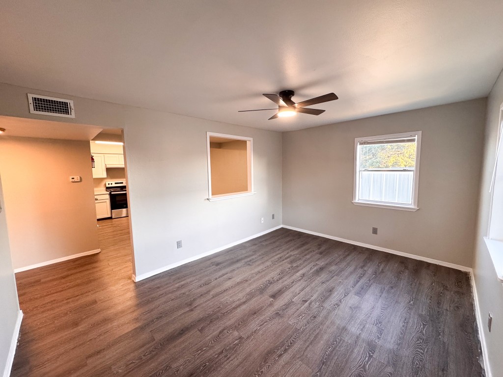 1050 Farm To Market Road 970, Unit B Florence, TX 76527 - Photo 1 of 26 a view of an empty room with wooden floor and a window
