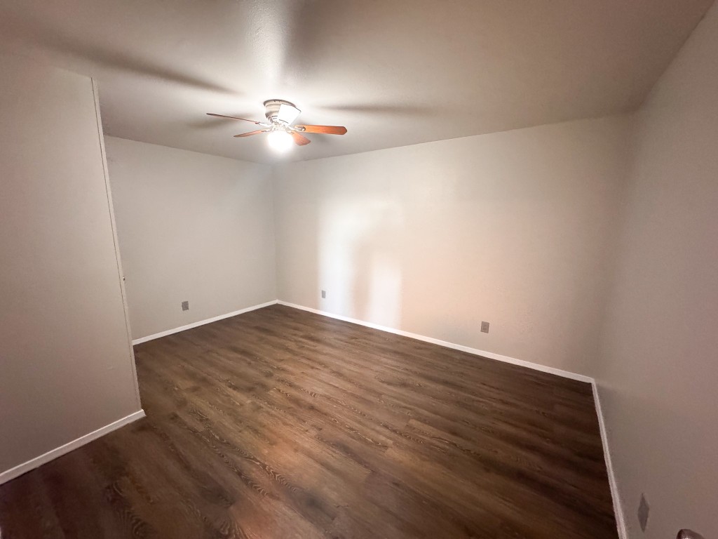 1050 Farm To Market Road 970, Unit B Florence, TX 76527 - Photo 14 of 26 an empty room with wooden floor and fan