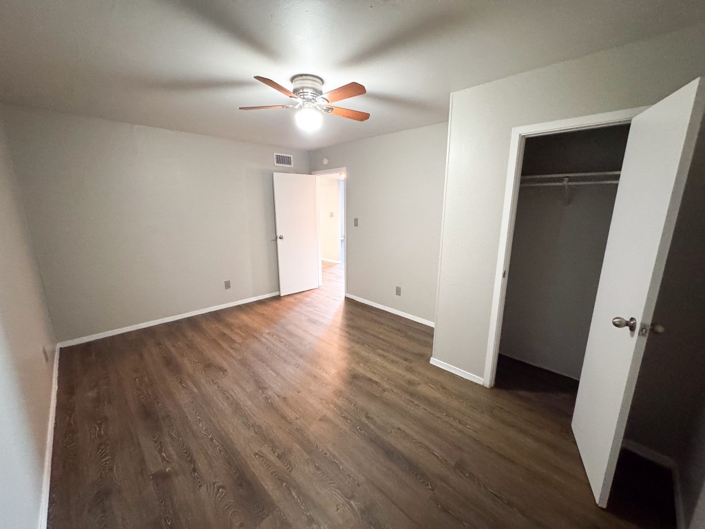 1050 Farm To Market Road 970, Unit B Florence, TX 76527 - Photo 15 of 26 a view of an empty room with wooden floor and a ceiling fan
