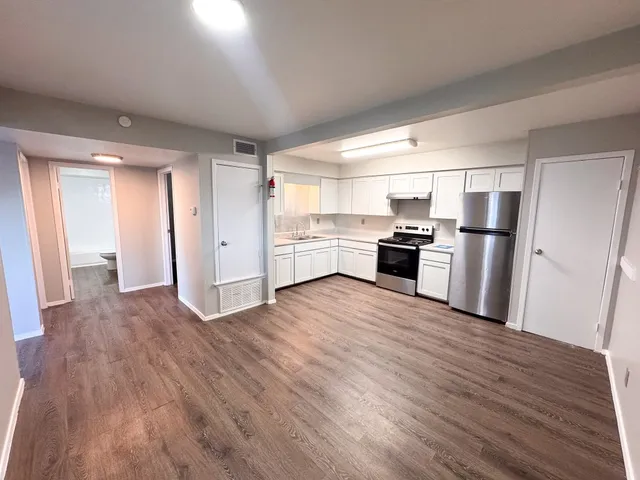 a kitchen with stainless steel appliances granite countertop a refrigerator and a stove top oven