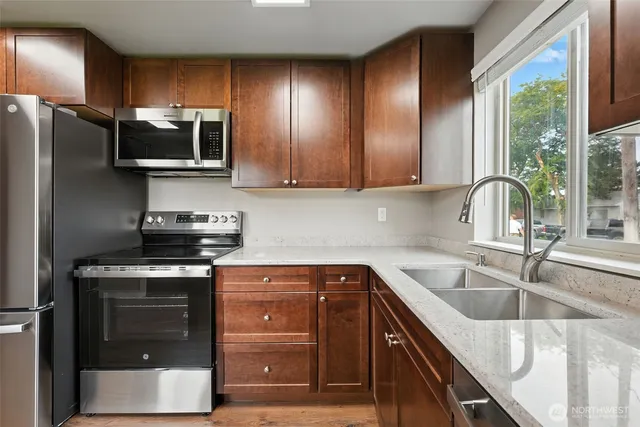 a kitchen with stainless steel appliances granite countertop a sink stove and refrigerator