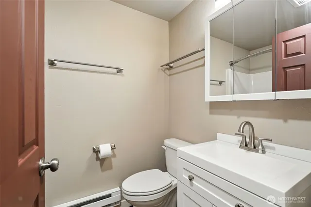 a bathroom with a sink mirror vanity and toilet