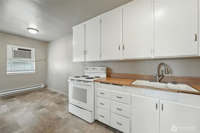 a kitchen with granite countertop white cabinets and white appliances