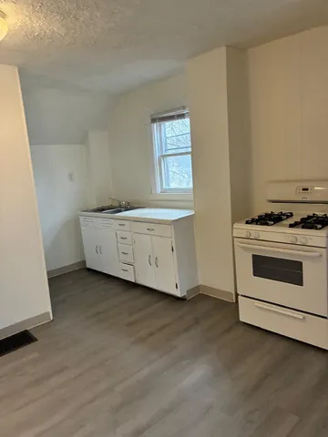 a kitchen with granite countertop a stove and a sink