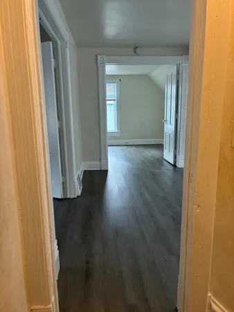 an empty room with wooden floor and a window