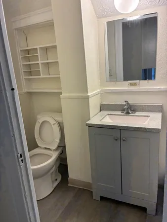 a bathroom with a sink a toilet and a mirror
