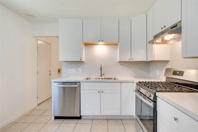 a kitchen with cabinets appliances and a window