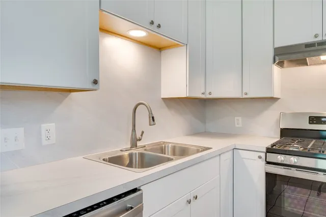 a kitchen with a sink cabinets and a stove