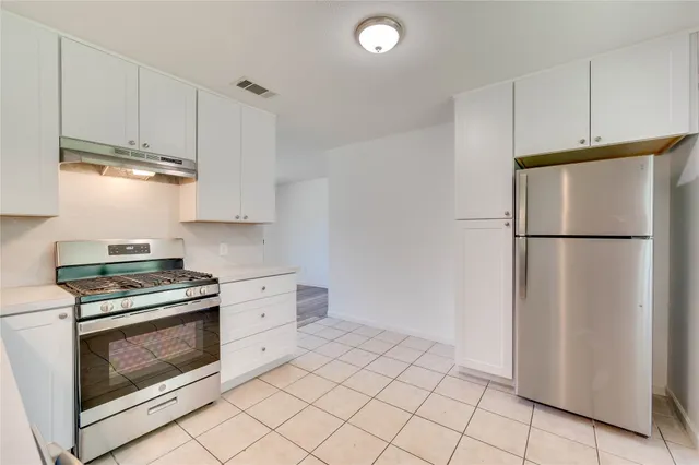 a kitchen with cabinets stainless steel appliances and counter space