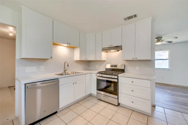 a kitchen with granite countertop white cabinets and white appliances