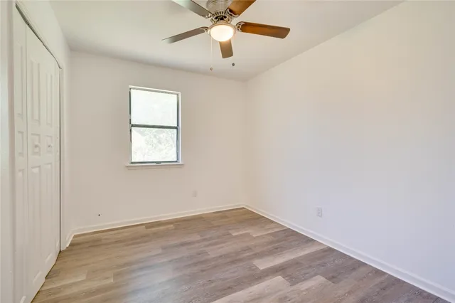 an empty room with a window and a fan