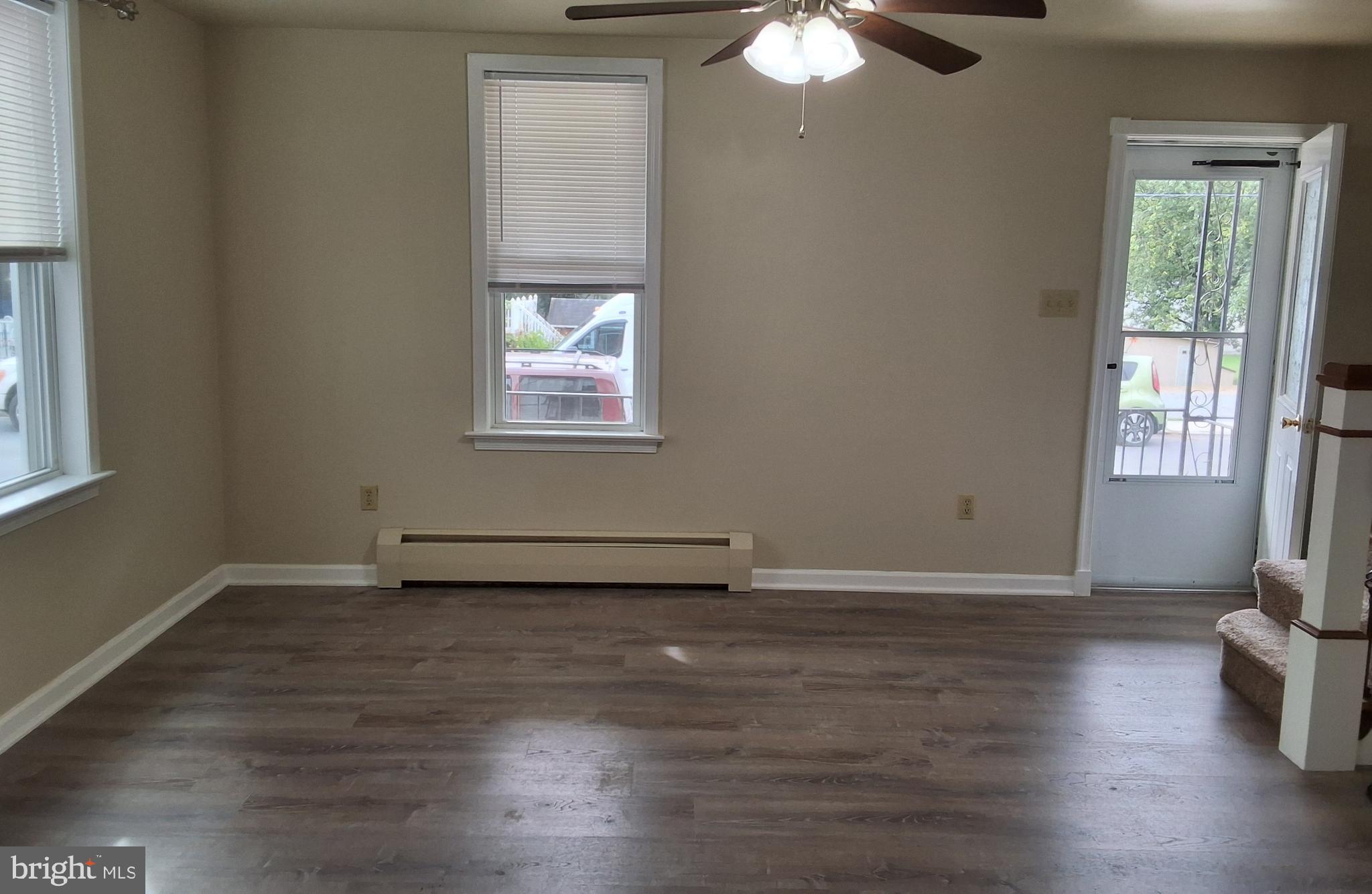 59 West Slokom Avenue Christiana, PA 17509 - Photo 4 of 28 an empty room with wooden floor chandelier fan and windows