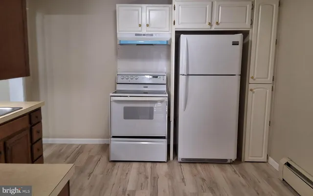 a kitchen with a refrigerator sink and cabinets