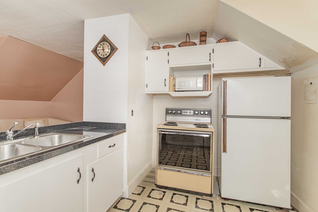 643 Center Street Raynham, MA 02767 - Photo 22 of 42 a kitchen with cabinets and a refrigerator
