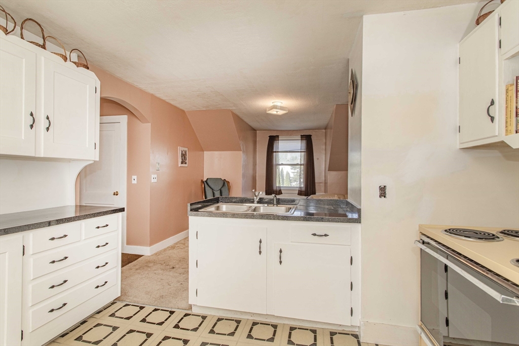 643 Center Street Raynham, MA 02767 - Photo 23 of 42 a kitchen with granite countertop a sink and cabinets