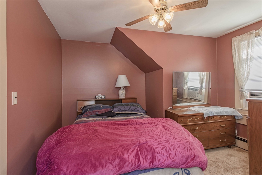 643 Center Street Raynham, MA 02767 - Photo 28 of 42 a bedroom with a bed and a chandelier