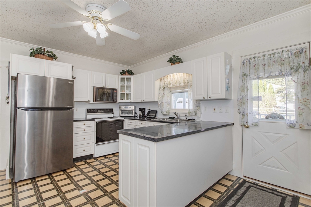 643 Center Street Raynham, MA 02767 - Photo 5 of 42 a kitchen with stainless steel appliances a sink stove refrigerator and cabinets