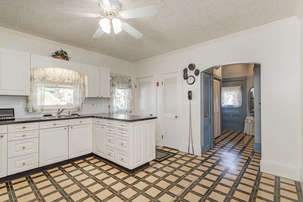 643 Center Street Raynham, MA 02767 - Photo 7 of 42 a kitchen with granite countertop white cabinets and white appliances