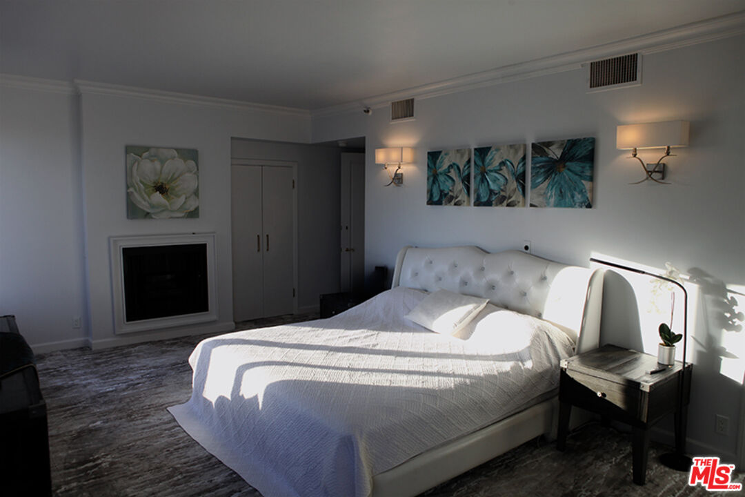 10550 Wilshire Boulevard, Unit 502 Los Angeles, CA 90024 - Photo 14 of 25 a bedroom with a bed and a fireplace