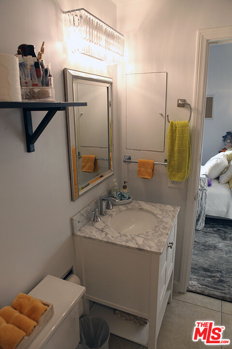 10550 Wilshire Boulevard, Unit 502 Los Angeles, CA 90024 - Photo 18 of 25 a bathroom with a granite countertop sink and a mirror