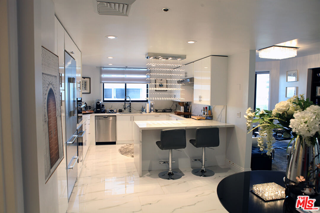 10550 Wilshire Boulevard, Unit 502 Los Angeles, CA 90024 - Photo 3 of 25 a room with stainless steel appliances kitchen island granite countertop a refrigerator and a sink